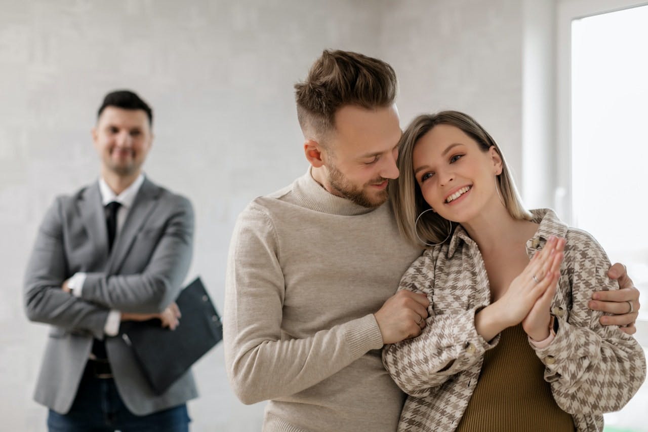 Happy couple hugging each other after buying a house.