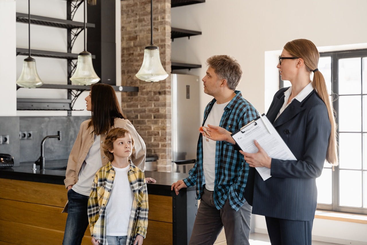 Estate agent leads a family around a potential new home.