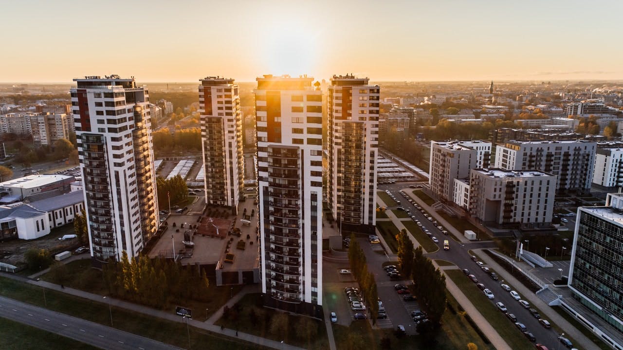 aerial view of group of high rise blocks of flats in front of a setting sun 