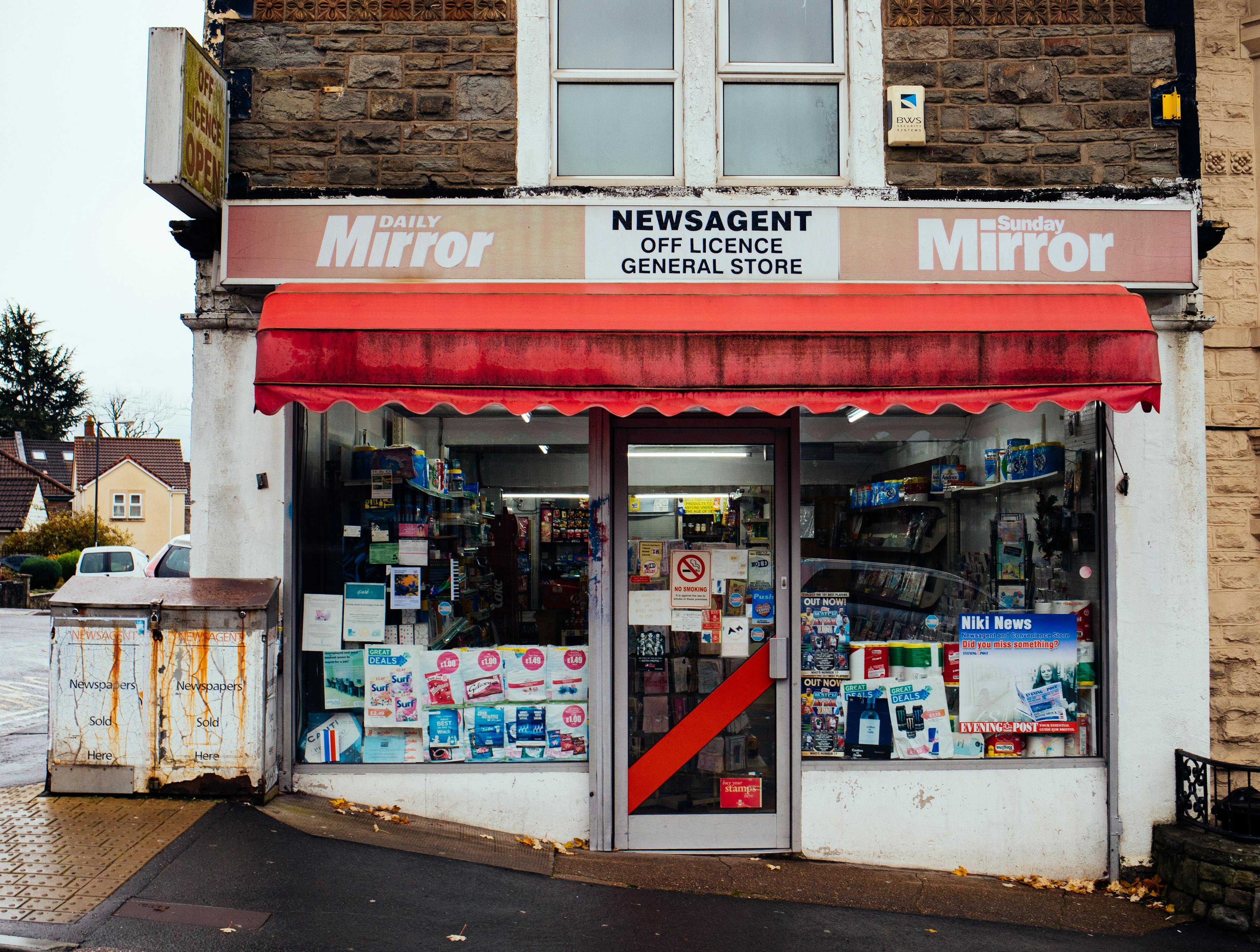 A local newsagent's shop front with a flat above.