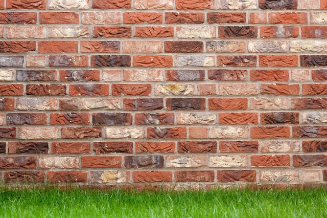 a garden lawn and brick wall